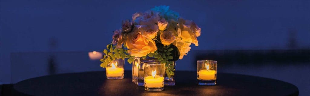 A bouquet of flowers with candles provides an elegant atmosphere for escort services.