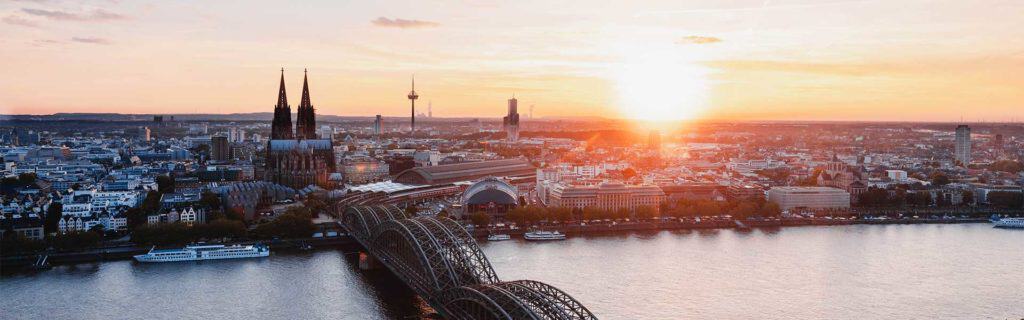 High-quality escort service image in Düsseldorf with a view of the Rhine and the city at sunset.