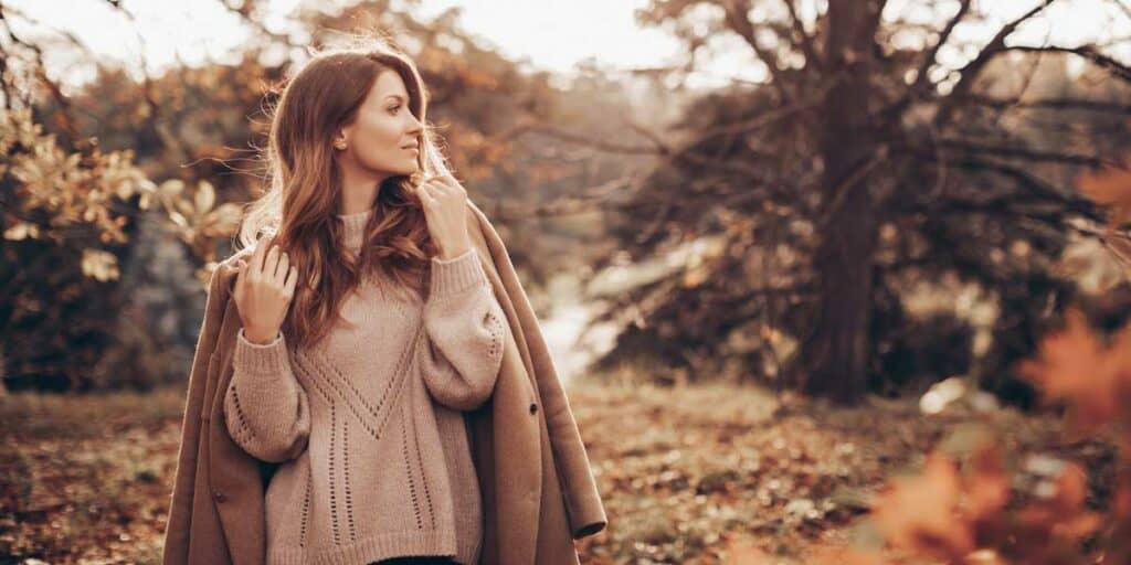 Exotic escort lady in the autumn forest, stylish and elegant, seductive and self-confident, perfect companion for unforgettable moments, escort service in Germany.